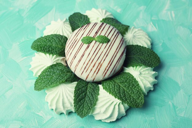 Meringues couleur menthe et gâteau savoureux sur fond de couleur