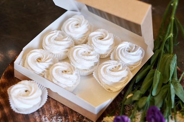 Meringues préparées ou guimauves ou cupcakes en pâtisserie sur table en bois