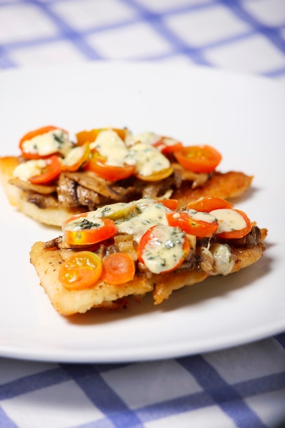 merlu fraîchement cuit avec champignons, tomates et fromage bleu