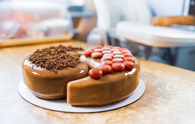 Merveilleux délicieux gâteau au chocolat en forme de Yin-Yang dans une cuisine confortable et lumineuse sur une table vintage en bois