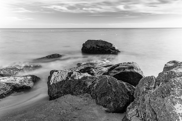 Merveilleux paysage marin avec des pierres sur la côte, photo N&B