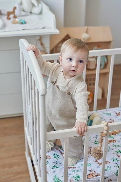 Merveilleux petit garçon aux yeux bleus dans un berceau Enfant jouant avec des jouets en crèche Développement précoce maternelle salle de jeux crèche Fête des enfants Fête des mères