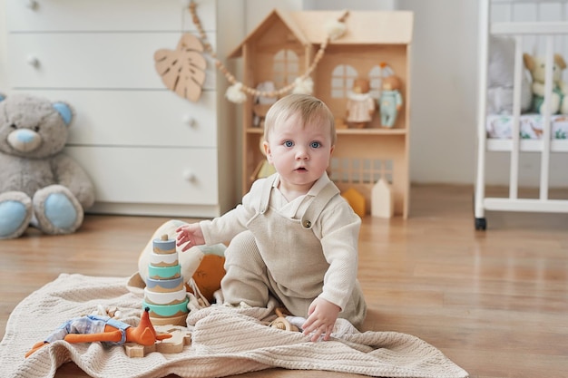 Merveilleux petit garçon aux yeux bleus Enfant jouant avec des jouets en crèche Développement précoce maternelle crèche salle de jeux Fête des enfants Fête des mères