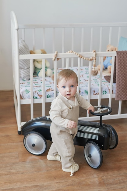 Merveilleux petit garçon aux yeux bleus Enfant jouant avec une voiture et des jouets en crèche Développement précoce maternelle crèche salle de jeux Fête des enfants Fête des mères