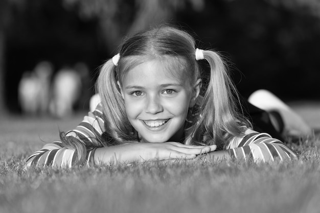 Mes cheveux mon look Enfant heureux avec un look beauté se détendre sur l'herbe verte Look vogue d'un petit mannequin Adorable fille sourire avec un look mode le jour d'été