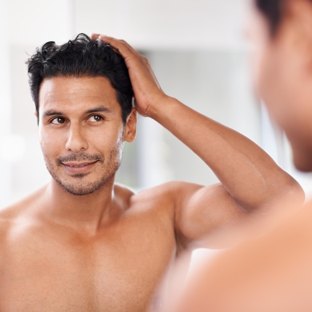 Mes cheveux sont parfaits Un beau jeune homme s'admirant dans le miroir