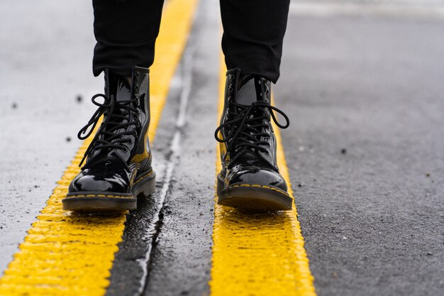 Mesdames chaussures en cuir de mode pour l'automne, le printemps, les pieds des filles debout sur la route goudronnée