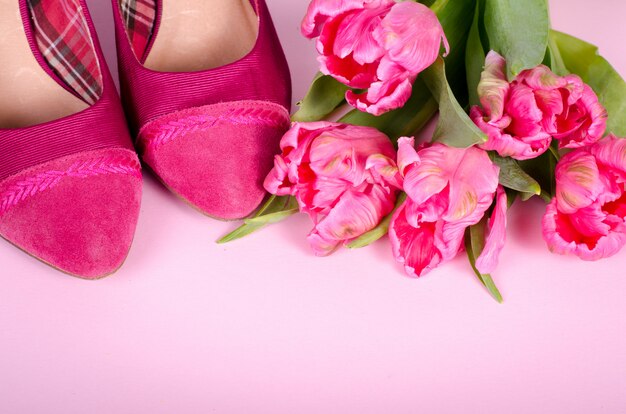 Mesdames rose chaussures à talons hauts et tulipes. Femme avec espace copie, symbole de concept pour les femmes, l&#39;amour, la Saint-Valentin et la journée de la femme, flou.