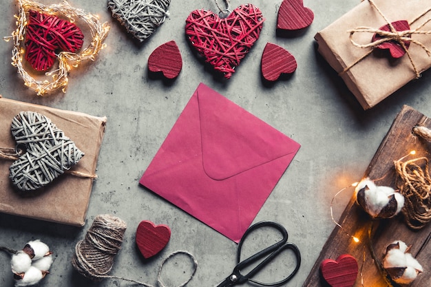 Message d'amour pour la Saint-Valentin. Préparation, emballage cadeau, fleurs en coton et carte postale
