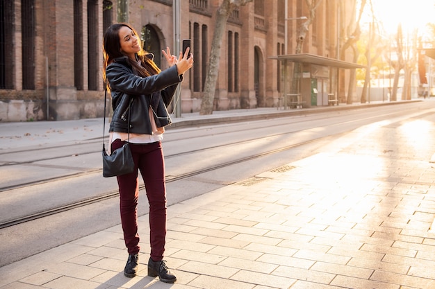 Message de femme faisant un appel vidéo dans la rue