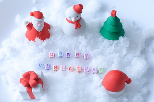Message de joyeux Noël fait avec des cubes de lettres sur la neige et des jouets