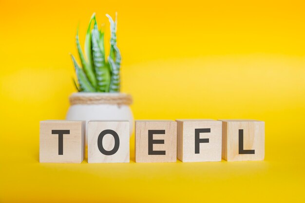 Message TOEFL fait avec des blocs de bois sur fond jaune