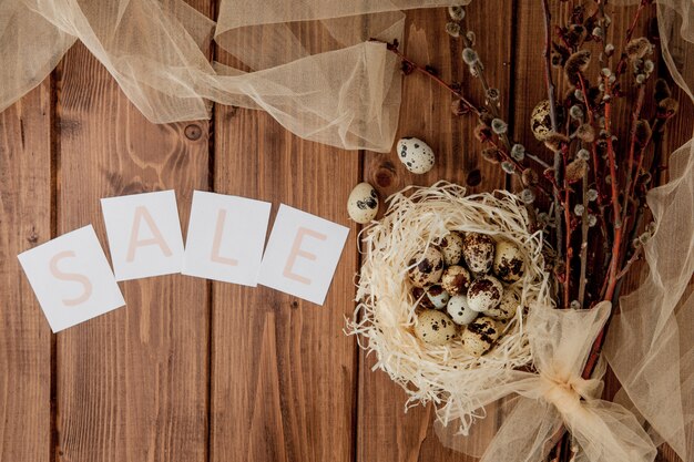 Photo message de vente de pâques avec des oeufs de pâques sur un fond en bois. vue de dessus