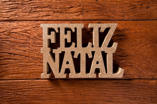 Message de voeux joyeux Noël sur fond en bois. Joyeux Noël écrit en portugais. Feliz natal.