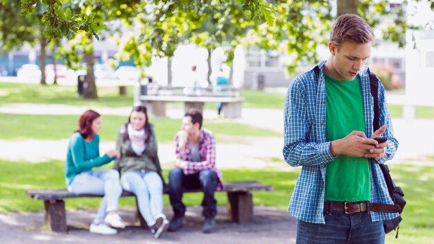 Messagerie texte Collège garçon avec des étudiants floues dans le parc