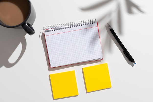 Messages importants présentés sur un bloc-notes et deux notes sur un bureau avec du café et un stylo Informations cruciales écrites sur un bloc-notes et des mémos sur une table avec une tasse