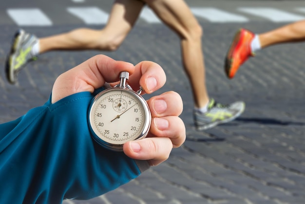 Mesure de la vitesse de course d'un athlète à l'aide d'une main de chronomètre mécanique avec un chronomètre sur le fond des jambes d'un coureur