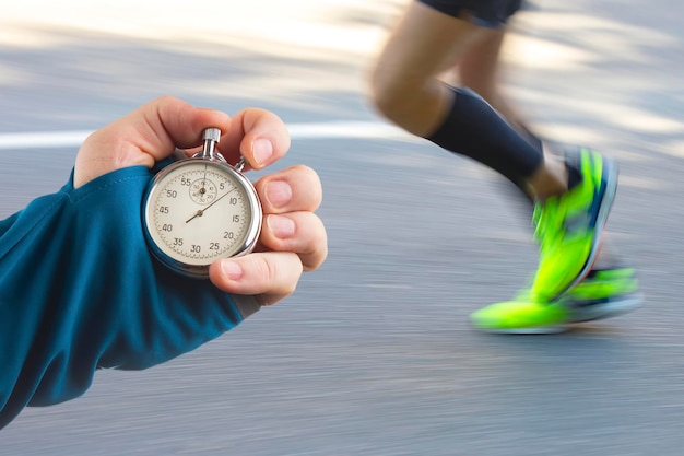 Mesure de la vitesse de course d'un athlète à l'aide d'une main de chronomètre mécanique avec un chronomètre sur le fond des jambes d'un coureur