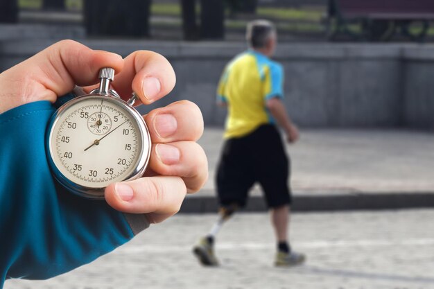 Mesure de la vitesse de course d'un athlète à l'aide d'une main de chronomètre mécanique avec un chronomètre sur le fond des jambes d'un coureur