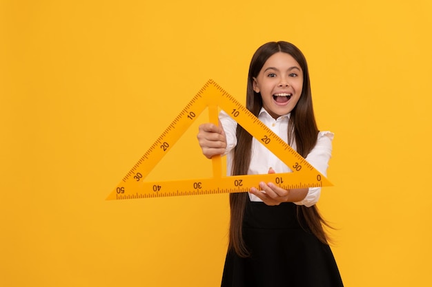 Mesurer et dimensionner l'éducation pour les mathématiques de l'enfant happy tween girl hold triangle