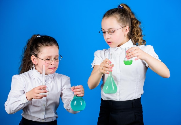 Mesures de sécurité Étude des petits enfants Leçon de chimie S'amuser avec la chimie Expérience éducative Amusement de chimie Journée de la connaissance Écolière avec des liquides chimiques colorés Concept d'éducation