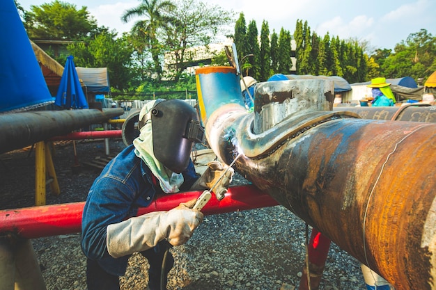 Le métal de travailleur masculin de soudure fait partie de la construction de pipeline de buse de machines, du pétrole et du gaz