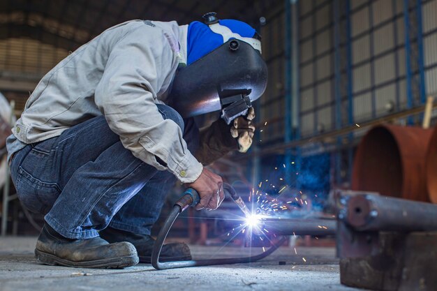 Le métal de travailleur masculin de soudure fait partie de la construction de pipeline de buse de machines, du pétrole et du gaz