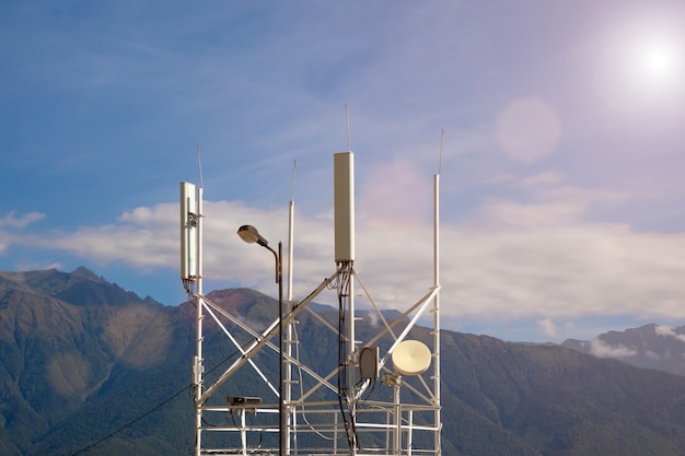 Émetteurs de télécommunications 4G, 5G. station de base cellulaire avec antennes émettrices près de la route sur fond de montagnes.