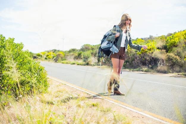 Mettre l&#39;accent sur la paille avec de l&#39;auto-stop blonde sexy sur fond