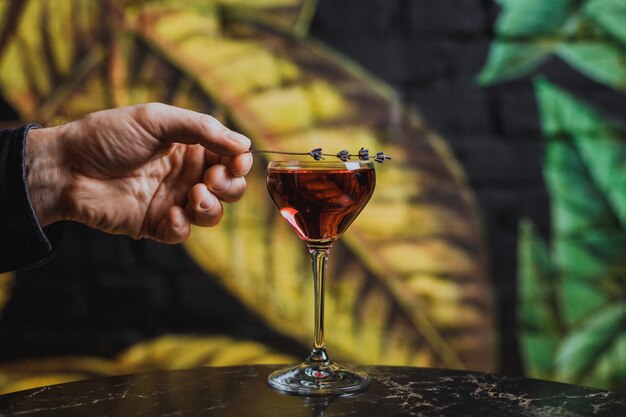 Mettre la garniture de lavande sur un verre à cocktail avec une boisson