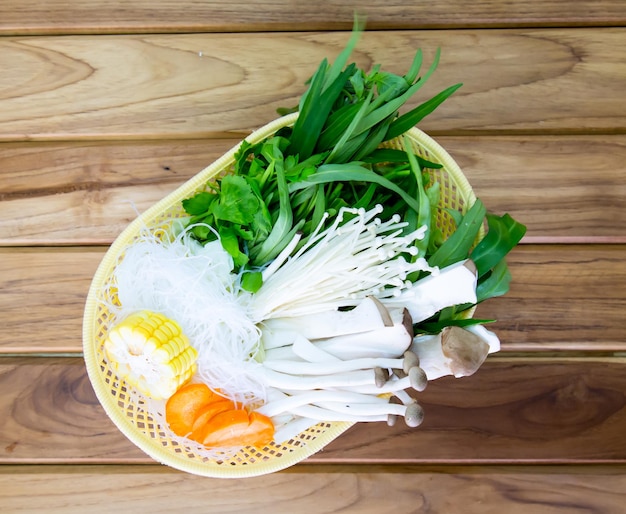 Photo mettre les légumes dans le panier sur fond de bois