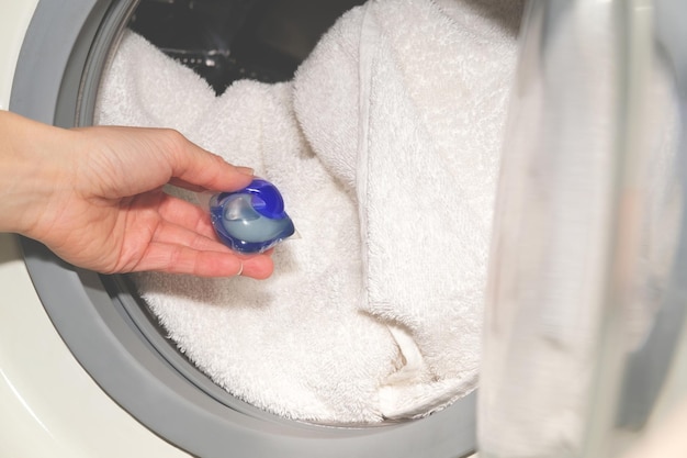 Mettre à La Main Une Capsule De Détergent Dans Des Serviettes En Coton  Blanc Dans Un Lave-linge