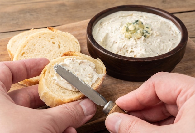 Mettre à la main une trempette au fromage orgonzola sur une tranche de pain Crème au fromage bleu