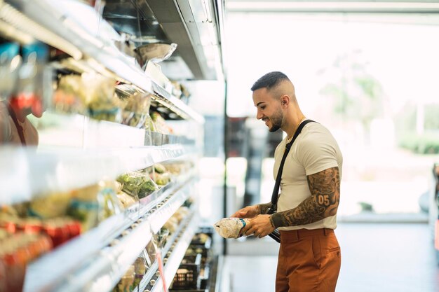 Mettre en place un athlète masculin tatoué de race blanche acheter de la nourriture au magasin