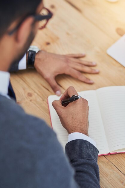 Mettre le stylo sur le papier Gros plan d'un homme d'affaires écrivant dans un cahier dans un bureau