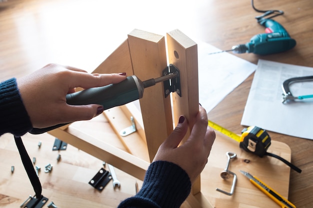 Meubles en bois d'assemblage de femme, fixation ou réparation de maison avec outil tournevis