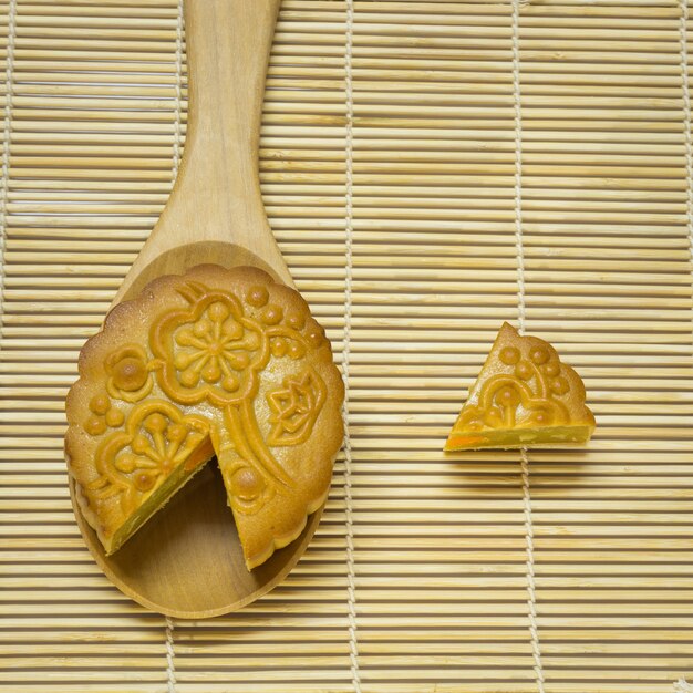 Mi-automne Festival gâteau de lune en cuillère sur un tapis en bois traditionnel