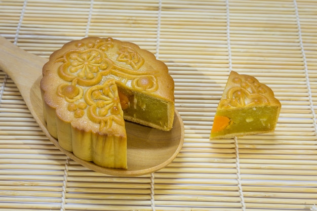 Mi-automne Festival gâteau de lune en cuillère sur un tapis en bois traditionnel