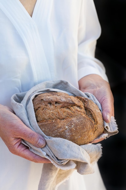 Miche fraîche de pain de seigle fait maison dans les mains de la femme