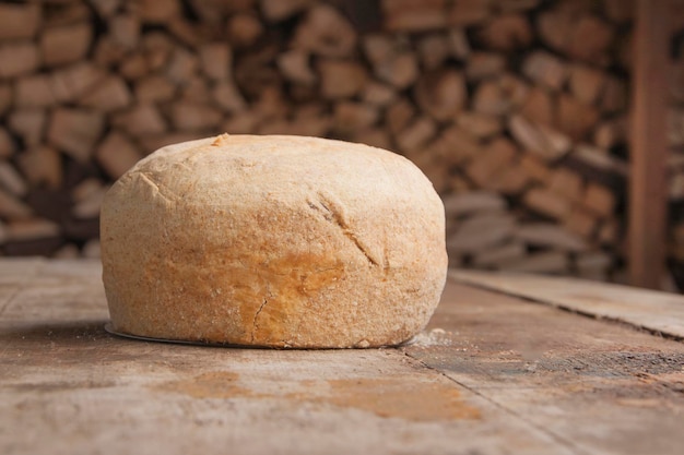 Miche de pain blanc sur une table en bois et derrière le bois