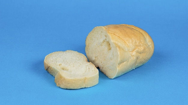 Une miche de pain blanc en tranches sur un fond bleu