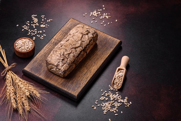 Une miche de pain brun avec des grains de céréales sur une planche à découper en bois