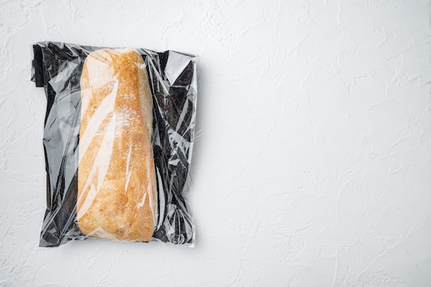 Miche de pain ciabatta à grains entiers artisanal frais dans un sac de marché, sur fond blanc, vue de dessus à plat, avec copyspace et espace pour le texte