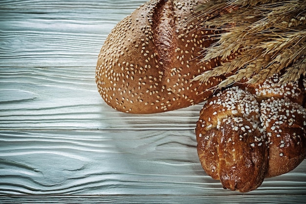 Miche de pain épis de blé sur planche de bois blanc