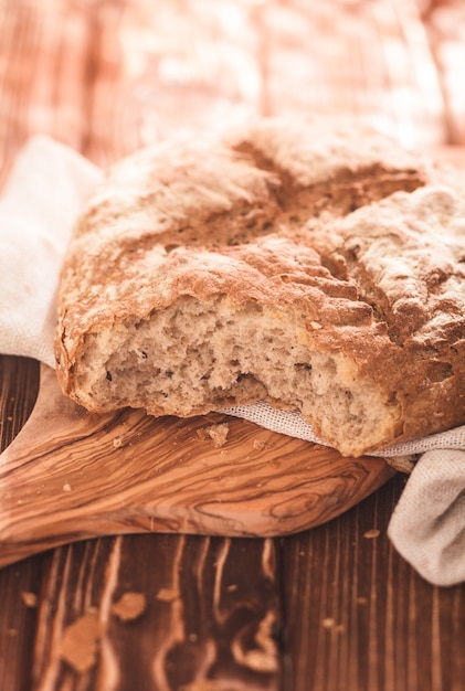 Miche de pain frais sur une planche à découper en bois