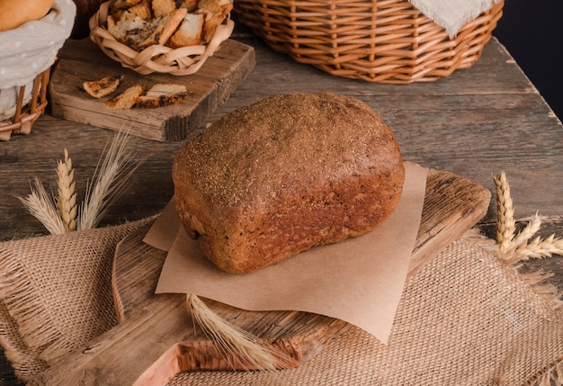 Miche de pain de seigle traditionnel sur fond de bois et toile de jute