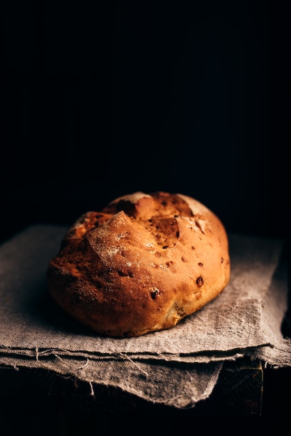 Miche de pain sur tissu gris. Fond sombre et espace de copie sur le dessus.