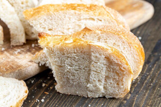 Miche de pain en tranches sur une planche à découper en bois