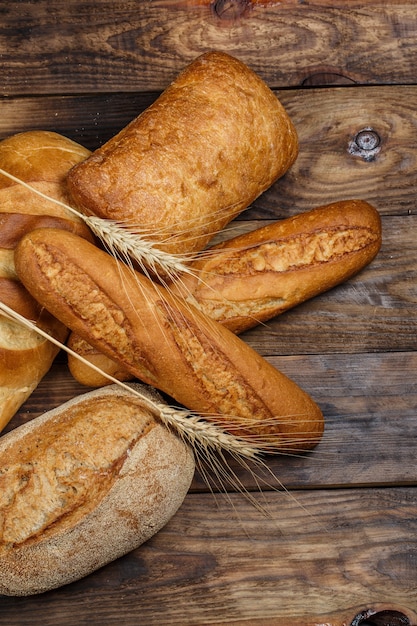 Miches de pain frais avec du blé et du gluten sur une table en bois