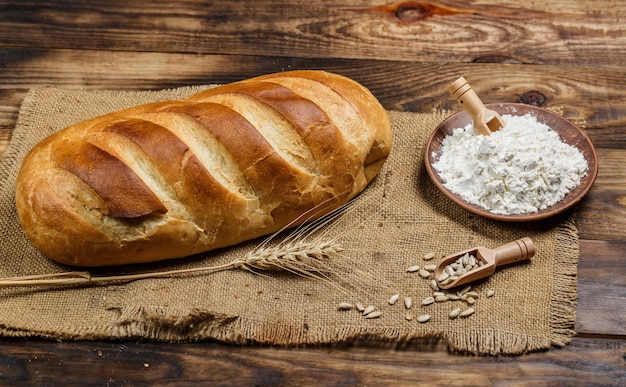 Photo miches de pain frais avec du blé et du gluten sur une table en bois